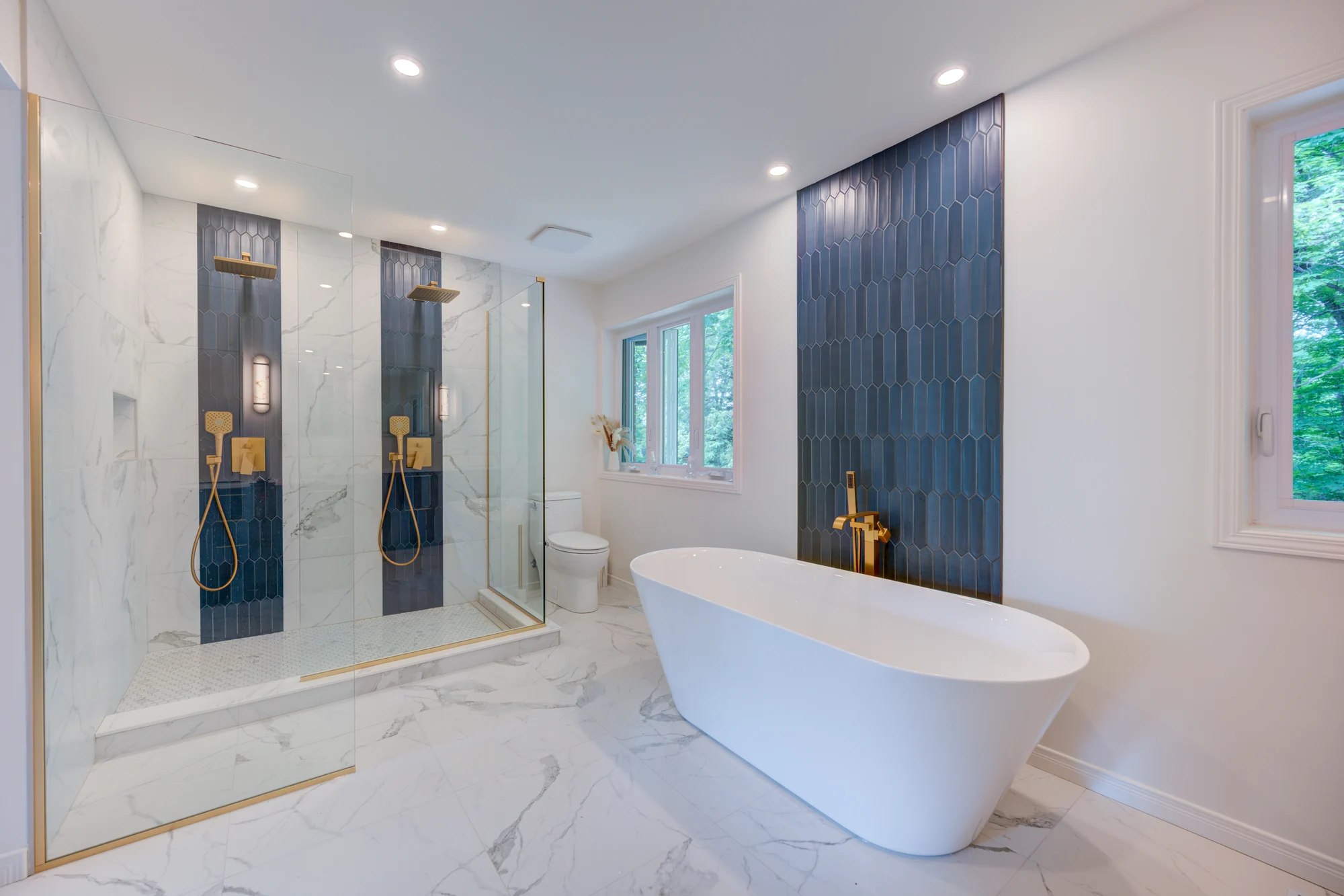 Salle de bain avec céramique blanche et mur bleu derrière la baignoire