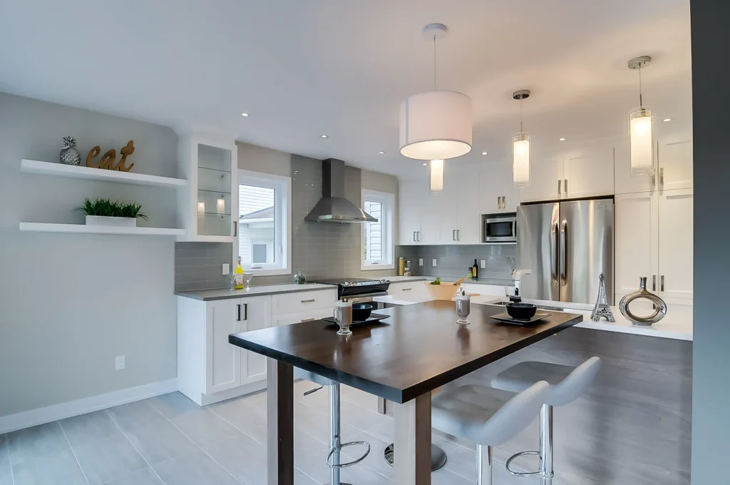 Cuisine blanche avec table noire et hotte en acier inoxydable