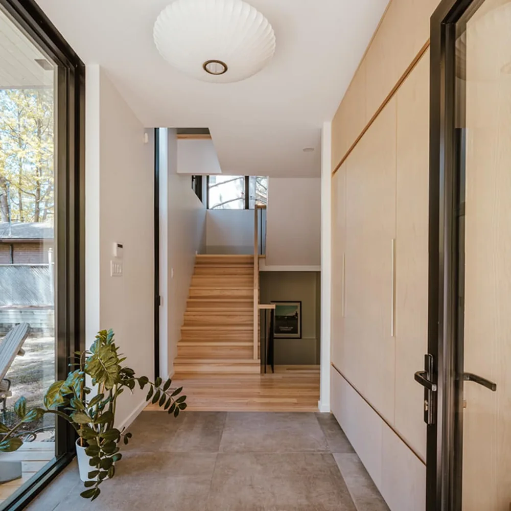 Entrée lumineuse avec escalier et portes en bois