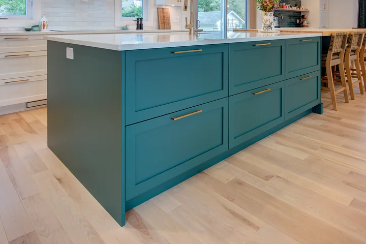 Plancher de bois franc clair dans une cuisine avec îlot bleu