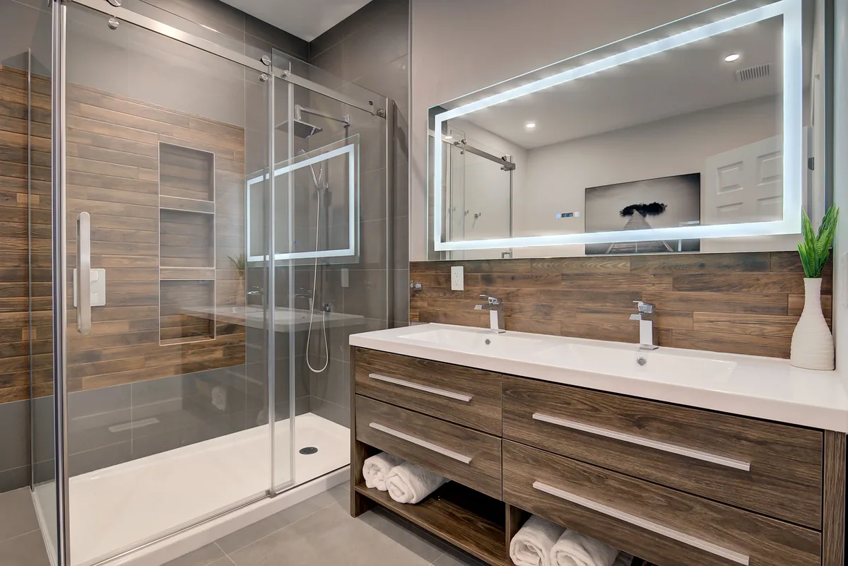 Salle de bain avec vanité en bois et douche vitrée